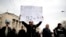 An anti-government protester holds a placard reading, "Europe, you owe us, do you remember 1992-1995?" during a protest in Sarajevo.