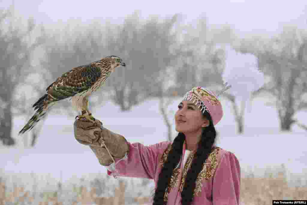 Дівчина&nbsp;в&nbsp;національному&nbsp;вбранні&nbsp;тримає&nbsp;на&nbsp;руці&nbsp;хижого птаха