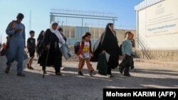 Deportasiya olunan əfqan qaçqınlar Əfqanıstan-İran sərhədi yaxınlığındakı qeydiyyat mərkəzində.