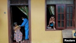 Şri Lankada yaşlı qadına evində peyvənd vurulur