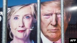 Портреты Хиллари Клинтон и Доналда Трампа на машине CNN за ограждением университета Hofstra накануне первых дебатов