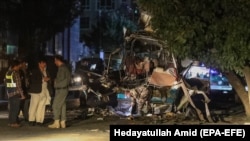 Afghan security officials inspect the scene of a bomb blast in Kabul on June 1.