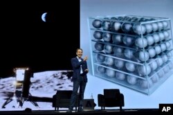 جف کونز در کنار تصویری از محموله‌ای که بعداً به‌عنوان نخستین اثر هنری به ماه فرستاده شد