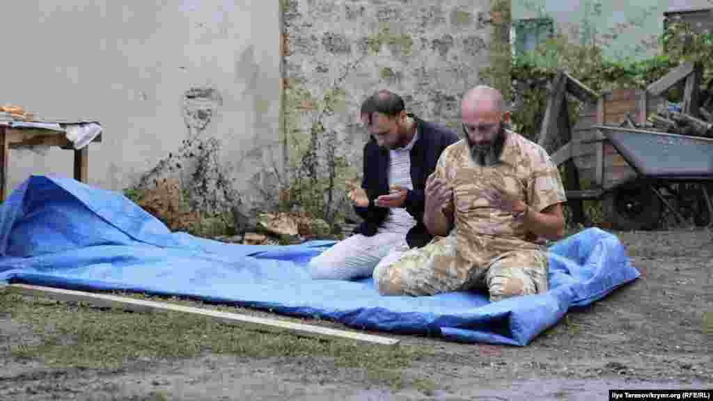 Faaller Ruslan Suleymanov ve Riza İzetov azbarda namaz qılalar. İzetov, Mustafayevni qarşılağanda &laquo;çekken memuriy ceza künlerine köre mutlaq rekordçı&raquo; dep şaqalaştı