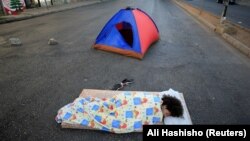 یکی از معترضان به سقوط شدید اخیر ارزش پوند لبنان. او برای بسته ماندن یک خیابان شب را در آن سپری کرده است