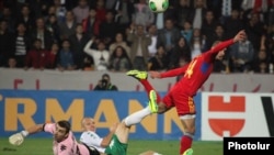 Армения - Футболист сборной Армении Юра Мовсисян (справа) отправляет мяч в ворота соперников, Ереван, 11 октября 2013 г.