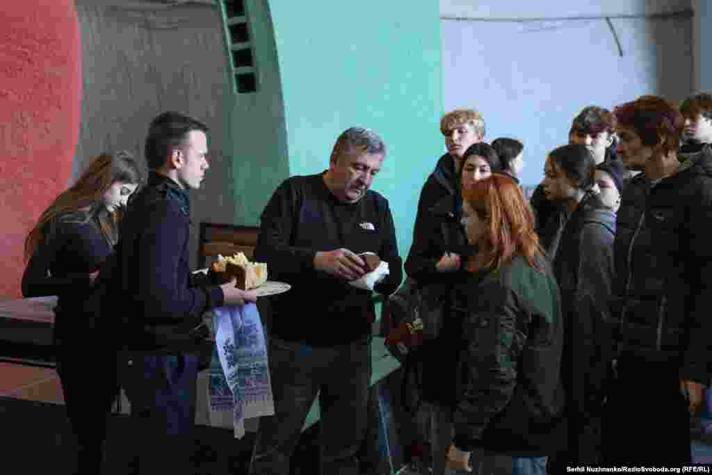 Хрещений батько Данила роздає шматки короваю його друзям, відповідно до народної традиції