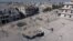 Syria -- A still image taken on September 27, 2016 from a drone footage obtained by Reuters shows people standing near craters and damaged buildings in a rebel-held area of Aleppo,