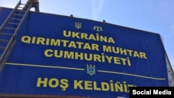 Qırım Maydanınıñ iştirakçileri Qırım kirişinde «Ukraina. Qırımtatar Muhtar Cumhuriyeti. Hoş keldiñiz!» levhasını tiklediler, 2015 senesi oktâbr 2 künü
