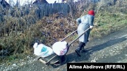 Женщина катит тачку с грузом. Город Зыряновск Восточно-Казахстанской области.   
