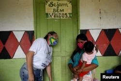 Түпкүлүктүү калктардын бири - мура элинин өкүлү болгон балалуу эне коронавируска каршы "Синовак" вакцинасы менен эмдеткени келди. Коррентеза кыштагы, Амазон аймагы, Бразилия. 2021-жылдын 13-февралы.