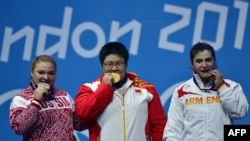 U.K. - China's Zhou Lulu (C) poses on the podium with her gold medal, next to Russia's Tatiana Kashirina (L) silver medal, and Armenia's Hripsime Khurshudyan (R) bronze medal, during the women's 75+kg group A weightlifting event, 05Aug2012