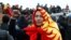 KYRGYZSTAN -- A demonstrator wearing the national flag gestures during a protest against the results of a parliamentary election in Bishkek, October 6, 2020