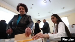 Armenia - A woman casts a ballot in a municipal election in Gyumri, March 30, 2025.