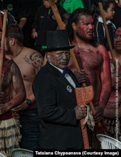 Тамэ Іці, вядомы актывіст Тухаэ з традыцыйным тату на твары на цырымоніі Дня ўрэгуляваньня адносін паміж народамі Тухаэ і Краўнам у 2014 годзе, дзе ўрад афіцыйна выбачыўся за гістарычныя несправядлівасьці. Танэатуа, Новая Зэляндыя