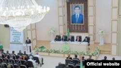 Türkmenistanda täze partiýa ak pata berenler prezident Berdimuhamedowyň ägirt uly suratynyň astynda göwnihoş ýagdaýda ornaşdylar. Aşgabat, 21-nji awgust, 2012.