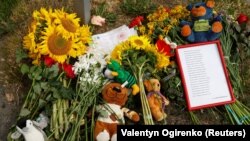 Винница шаарынын борборунда Орусиянын ракеталык чабуулунан 4 жашар Лиза аттуу кыз каза болгон жерге кишилер таштап кеткен гүлдөр жана оюнчуктар. Винница, 15-июль, 2022-жыл