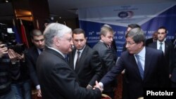 Հայաստանի և Թուրքիայի արտգործնախարարները ողջունում են միմյանց «Արմենիա Մարիոթ» հյուրանոցում: 12-ը դեկտեմբերի, 2013թ.