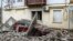 A car lies under debris outside a building damaged as a result of a Russian air strike on Kherson on February 2.