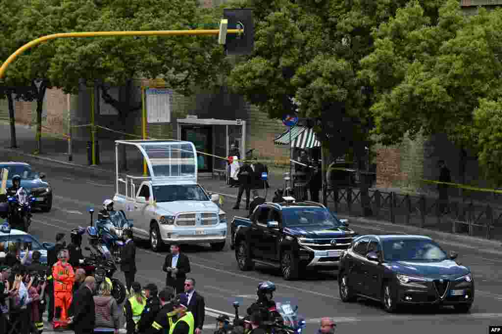 Građani stoje uz cestu dok se prevozi lijes pape Franje.