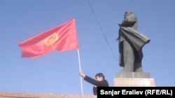 Архівна світлина. Чоловік із киргизьким прапором біля пам'ятника Володимиру Леніну в центрі міста Ош. Міська влада зняла цей пам'ятник у червні