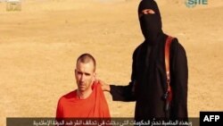 Ýüzi maskaly söweşijiniň britan raýatyny öldürmek bilen haýbat atýana meňzeýän pursatlaryny görkezýän "YD" söweşijileri tarapyndan ýaýradylan wideodan bir bölek. 