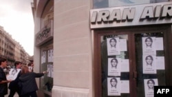 اعضای سازمان گزارشگران بدون مرز در اعتراض به بازداشت فرج سرکوهی عکس های وی را بر روی شیشه دفتر «ایران ایر» در پاریس می چسبانند.