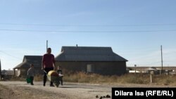 Жители Акжара возвращаются домой с водой.