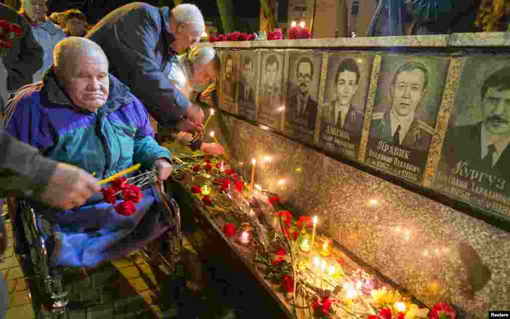 Ліквідатори аварії на ЧАЕС запалюють свічки біля меморіалу в пам&rsquo;ять про пожежників і працівників станції, які померли після Чорнобильської катастрофи, місто Славутич, 26 квітня 2013 року