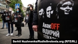 Під час акції «АвакOFF відкрий докази» біля будівля МВС. Активісти тримають плакати із зображенням Андрія Антоненка, Юлії Кузьменко та Яни Дугарь, які є підозрювані у справі про вбивство Павла Шеремета. Київ, 28 травня 2020 року 
