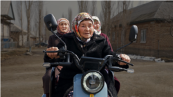 Мотороллерге курбуларын салып,  айылчылаган Күмүшай апа