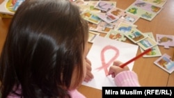 ВИЧ-инфицированная девочка рисует красную ленту, символ борьбы со СПИДом, в шымкентском Центре матери и ребёнка. 30 ноября 2020 года. О массовом заражении детей ВИЧ в городе стало известно в 2006 году