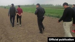 Подозреваемый в убийстве ведет следователей к месту, где закопано тело ребенка.