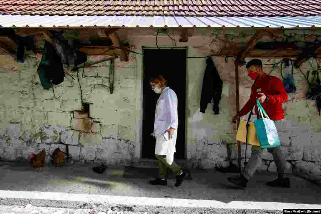 Медичний працівник та волонтер Червоного Хреста йдуть вакцинувати наступного селянина