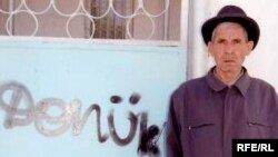 Graždan aktiwisti Gurbandurdy Durdykulyýew öz ýaşaýan howlusynyň gapysyna näbelli adamlaryň ýazan “Dönük” diýen ýazgysynyň ýanynda. Balkanabat, 24-nji iýun, 2008.