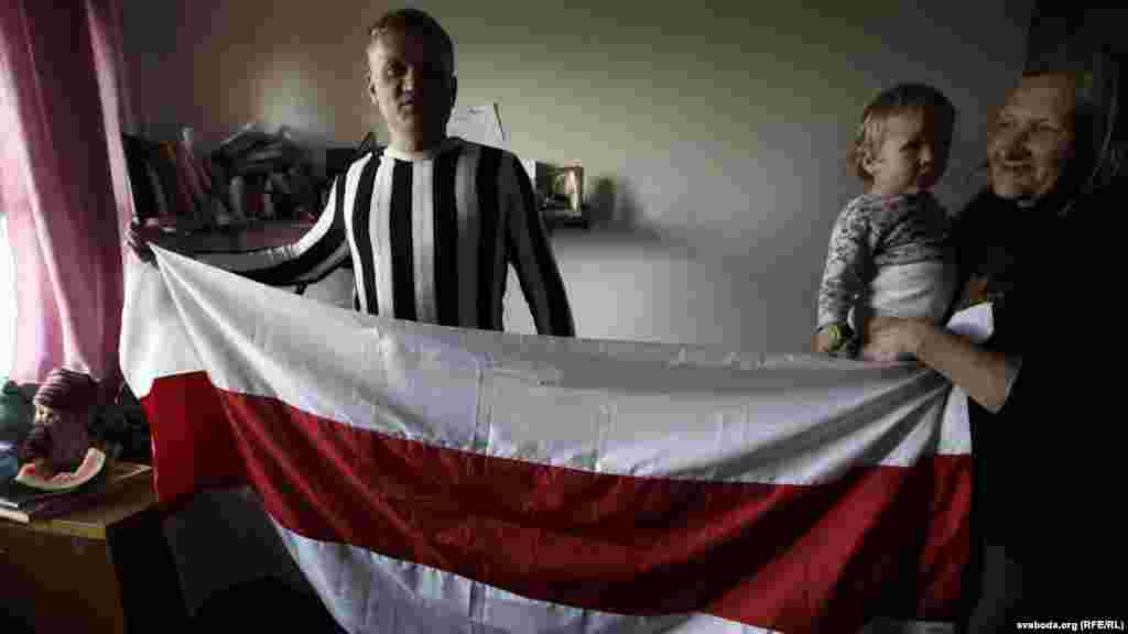 Kavalenka and his mother, Lidzia, and his daughter, Vika, celebrate his release by unfurling the banned Belarusian national flag.