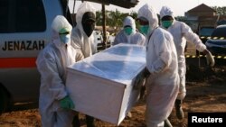 Индонезияда коронавирустан өлгөн кишинин сөөгүн жерге берип жатышат. 