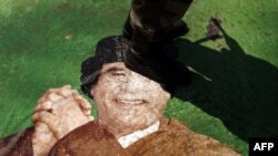 Ливиялик исëнчи 42 йиллик диктатор суратини топтамоқда.