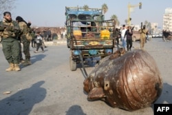 سردیس سرنگون‌شده حافظ اسد، رئیس‌جمهور پیشین سوریه و پدر بشار، در خیابان‌های شهر حماه