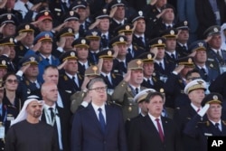 Президентът на ОАЕ Мохамед бин Зайед, сръбският президент Александър Вучич, министърът на отбраната Братислав Гашич и началникът на Генералния щаб на армията ген. Милан Мойсилович (от ляво надясно на първия ред) слушат сръбския химн на военния парад в Белград, 20 септември 2025