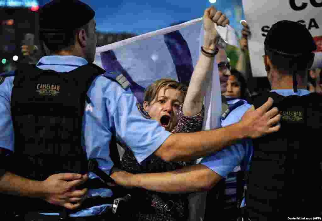 Протестуючі вигукують антиурядові гасла під час акції протесту перед будівлею уряду в Бухаресті, Румунія, 30 травня. Близько 2000 людей вийшли на мітинг після того, як&nbsp; більшість суддів Конституційного суду Румунії ухвалили рішення, яке зобов&#39;язує президента країни звільнити&nbsp;головного антикорупційного прокурора країни Лауру Ковеші. Тоді румуни вийшли на масові протести з вимогою захистити її. Уряд звинуватив Ковеші в порушенні Конституції, але її прихильники заявили, що вона розслідувала корупцію серед політичної еліти Румунії. (AFP/Daniel Mihailescu)