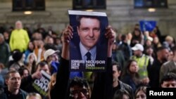 Susținători ai lui Nicușor Dan se bucură după anunțarea sondajelor exit-poll, în turul doi al alegerilor prezidențiale din România.
