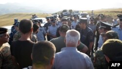 Armenian war veterans and army volunteers with the intention of unblocking the Lachin Corridor are confronted by law enforcement officers on a road just before the checkpoint.