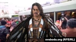 Каляж: на пярэднім пляне — Дэні Трэха на постэры фільма «Мачэтэ» (2010), на заднім — затрыманьне грамадзянаў «людзьмі ў цывільным» у тралейбусе, Менск, 15 сакавіка 2017 году