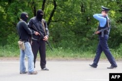 Про-російські бойовики разом з міліціонером чергують на одному з блокпостів на дорозі Донецьк-Маріуполь, 15 травня 2014 року