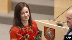 Новому премьер-министру Литвы Инге Ругинене вручают букет цветов на заседании Сейма Литовской Республики в Вильнюсе, 26 августа 2025 года