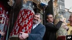 گروهی از یهودیان آمریکایی در حال حمل استوانه‌های تورات در کنیسه‌ای در بافت قدیمی دمشق، ۱۸ فوریه ۲۰۲۵