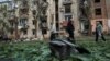 Local residents walk near an apartment building damaged by a Russian air strike in Kharkiv on May 5.