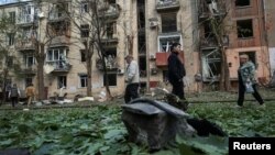 Local residents walk near an apartment building damaged by a Russian air strike in Kharkiv on May 5.