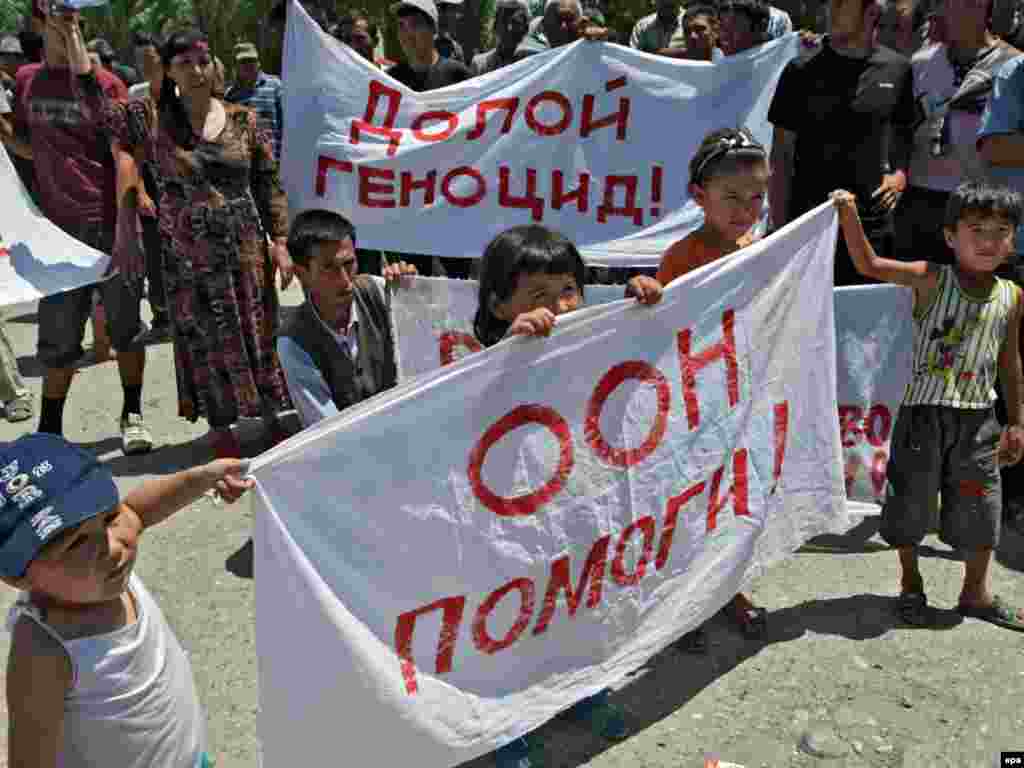  Ребенок держит плакат с надписью – «ООН помоги!»,  в лагере беженцев на узбекской границе. 19 июня 2010 года.